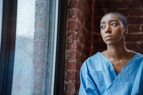 衬衫站在棕色砖墙旁边的蓝色按钮的女人 · 免费素材图片