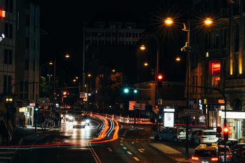 夜间建筑物附近道路上的汽车 · 免费素材图片