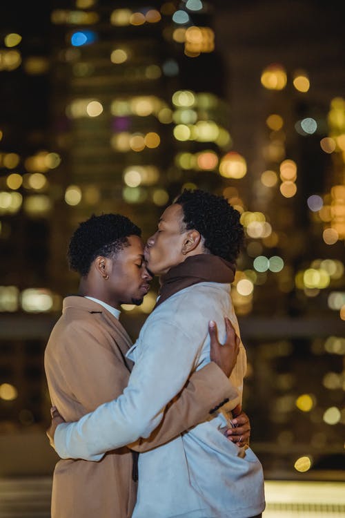 白色礼服衬衫的男人亲吻棕色礼服衬衫的女人 · 免费素材图片