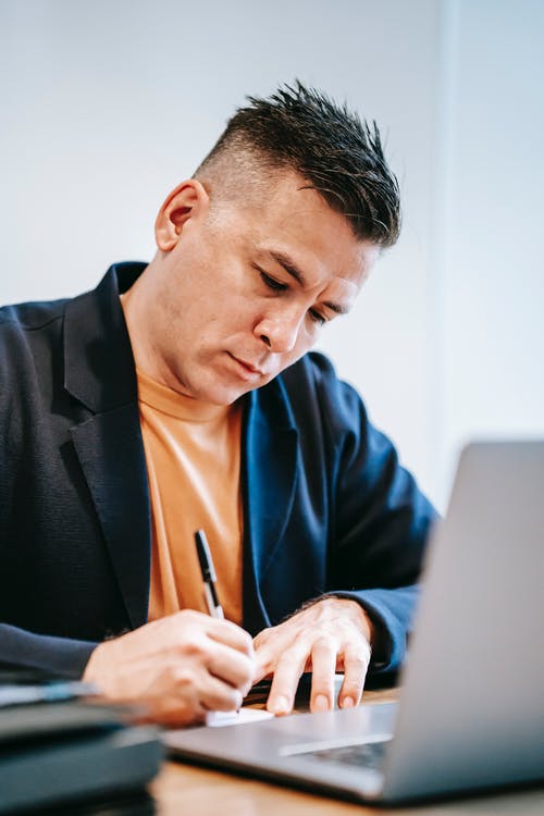 使用macbook的蓝色西装外套的男人 · 免费素材图片