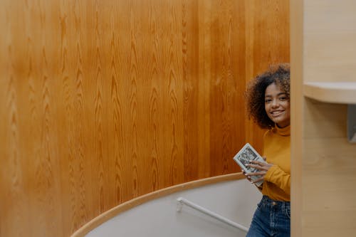 拿着白卡的蓝色牛仔夹克的女人 · 免费素材图片