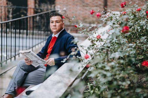 坐在白色的混凝土长凳上的黑色西装的男人 · 免费素材图片