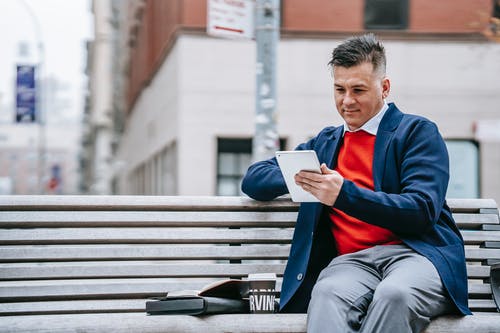 蓝色和红色的长袖衬衫阅读书中的男人 · 免费素材图片