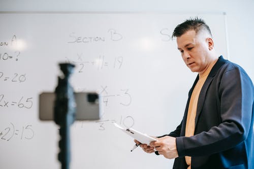 拿着智能手机的黑色西装外套的男人 · 免费素材图片