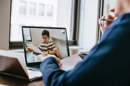 坐在西装上使用macbook的黑色西装外套的男人 · 免费素材图片