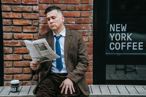 穿着灰色西装的男人读报纸 · 免费素材图片