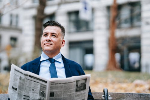 拿着报纸的蓝色西装外套的男人 · 免费素材图片
