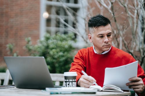 使用macbook的红色毛衣的男人 · 免费素材图片