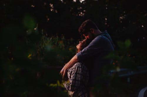 蓝色连帽衫亲吻男人穿着白色和黑色格子衬衫的男人 · 免费素材图片