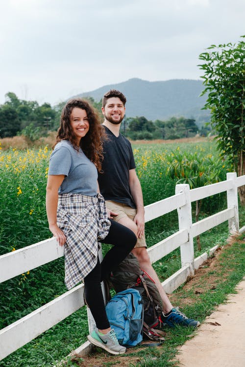 蓝色的t恤和黑色和白色格仔的裤子，站在黑色的女人旁边的女人 · 免费素材图片