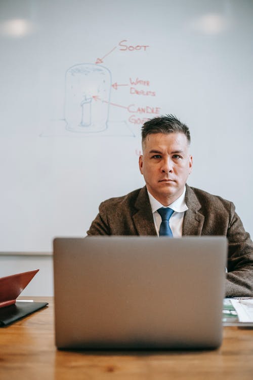 使用macbook的棕色西装外套的男人 · 免费素材图片