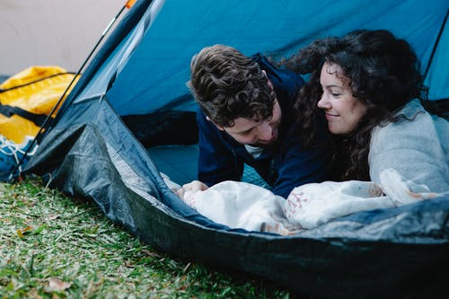 2名躺在蓝色和白色帐篷上的女人 · 免费素材图片