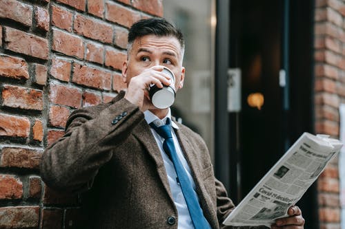 从白色陶瓷杯喝黑衣的男人 · 免费素材图片
