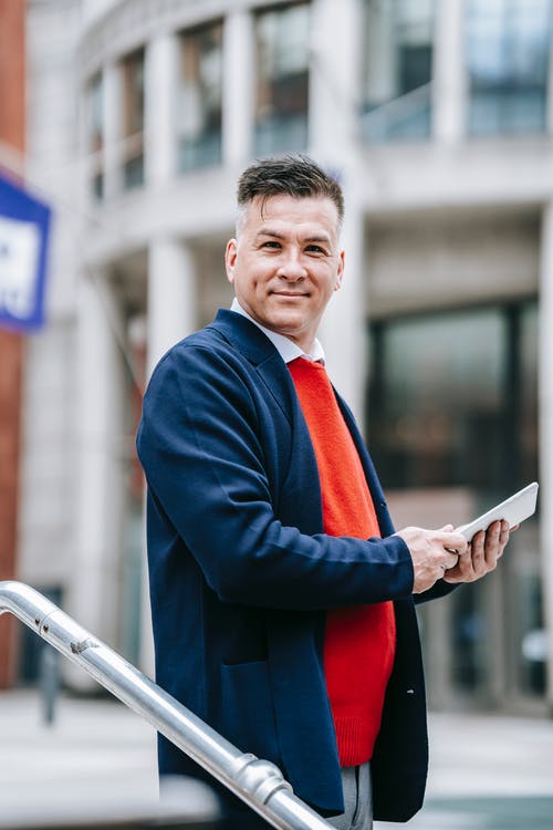 拿着白色平板电脑的蓝色西装外套的男人 · 免费素材图片