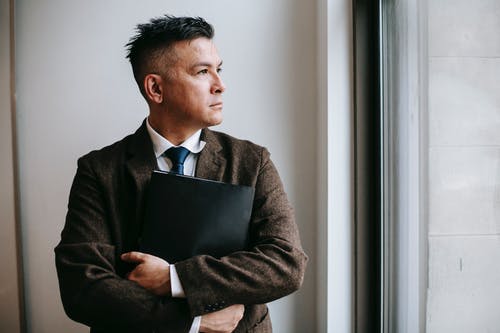 拿着黑色便携式计算机的黑色西装外套的男人 · 免费素材图片