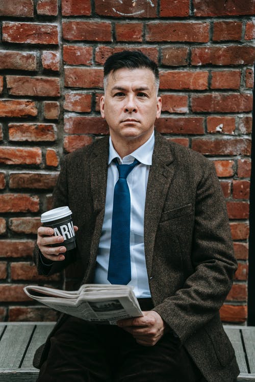 拿着黑色和白色陶瓷杯的黑色西装外套的男人 · 免费素材图片