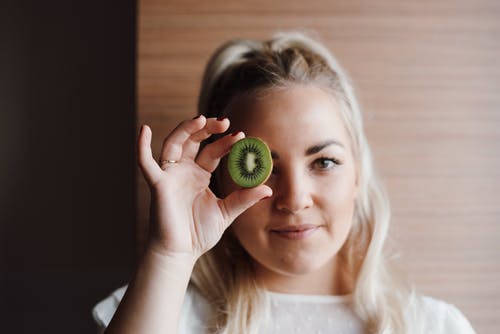 女孩抱着绿色的圆形水果 · 免费素材图片