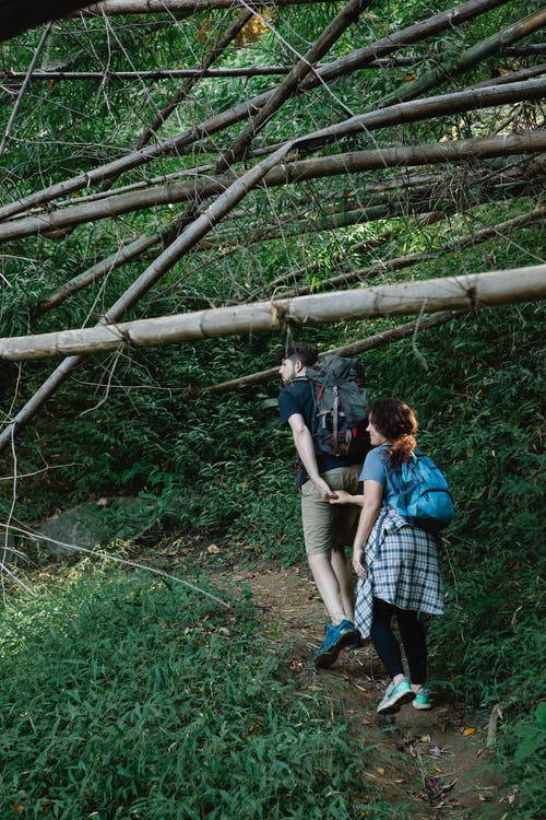 男人和女人站在棕色的木栅栏旁边 · 免费素材图片
