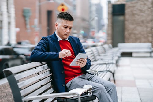 坐在椅子上的长椅上的蓝色西装外套的男人 · 免费素材图片