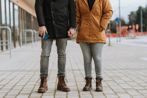 棕色外套和蓝色牛仔牛仔裤在人行道上行走的女人 · 免费素材图片