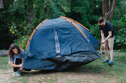 坐在露营帐篷上的黑色t恤的男人 · 免费素材图片