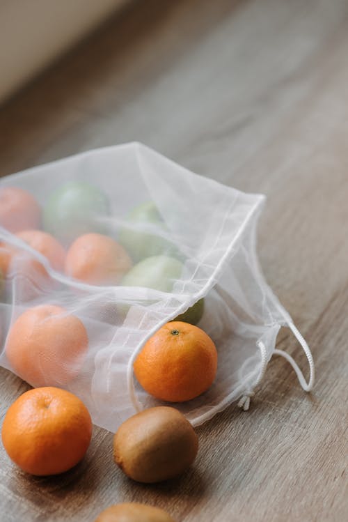 白色纺织品上的橙色水果 · 免费素材图片