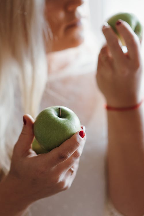 女人抱着青苹果水果 · 免费素材图片