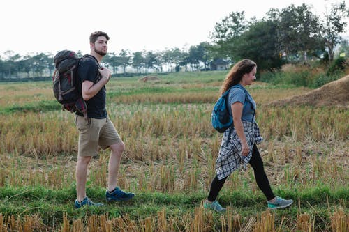 男人和女人在绿草地上行走 · 免费素材图片