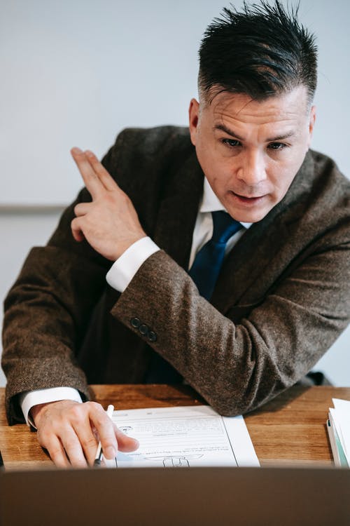 坐在桌前的棕色西装外套的男人 · 免费素材图片