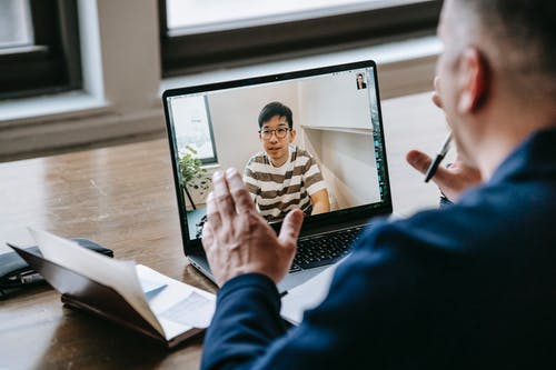 使用macbook Pro的蓝色长袖衬衫的男人 · 免费素材图片