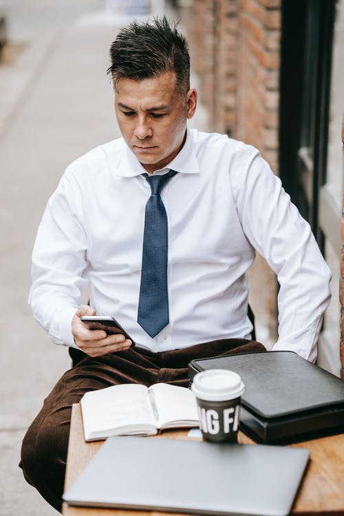 坐在椅子上的白色礼服衬衫和黑色领带的男人 · 免费素材图片