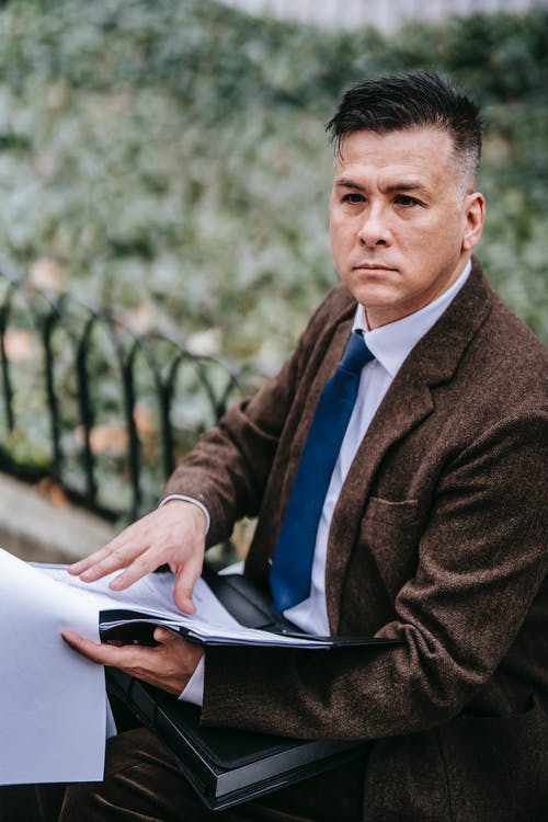 坐在白色椅子上的黑色西装外套的男人 · 免费素材图片