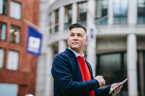 拿着红色书的蓝色西装外套的男人 · 免费素材图片