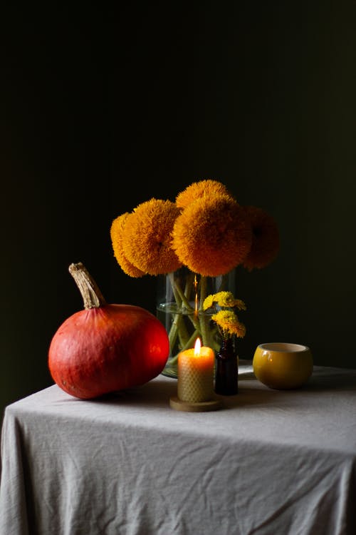 红苹果果实旁边的花瓶中的黄色花朵 · 免费素材图片