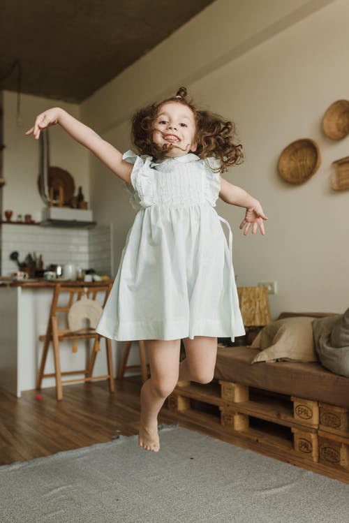 站在棕色木地板上的白色连衣裙的女孩 · 免费素材图片