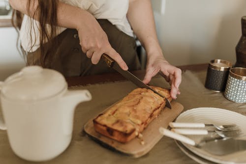持刀切片面包的人 · 免费素材图片