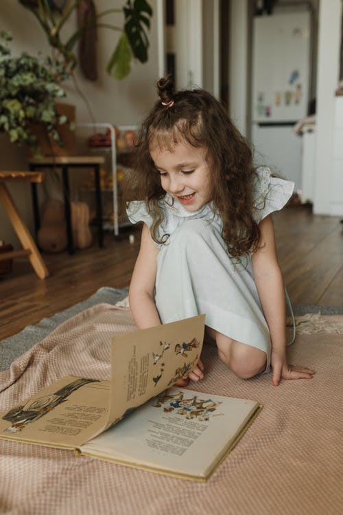 白色无袖连衣裙看书的女孩 · 免费素材图片
