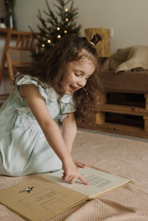 蓝绿色礼服的女孩坐在床上 · 免费素材图片
