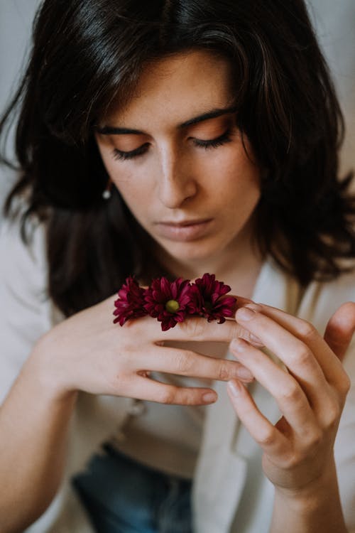拿着桃红色花的白衬衫的妇女 · 免费素材图片