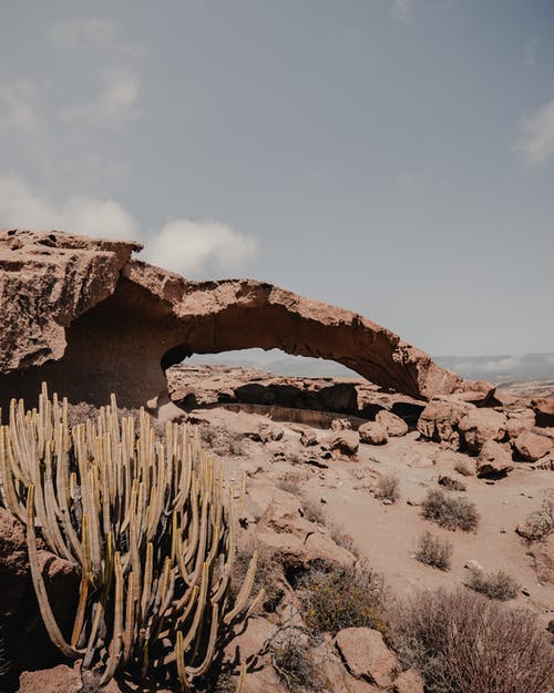 在白色沙滩上的棕色岩层 · 免费素材图片