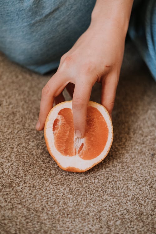人控股切成薄片的橙色水果 · 免费素材图片