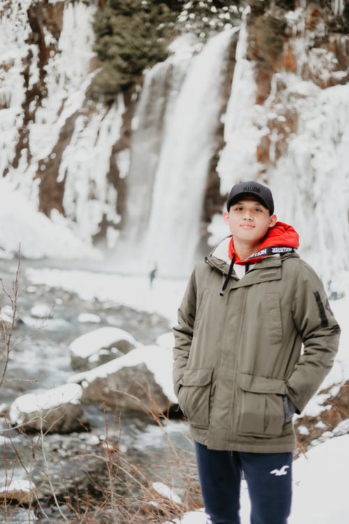 站在大雪覆盖地面上的灰色外套的女人 · 免费素材图片