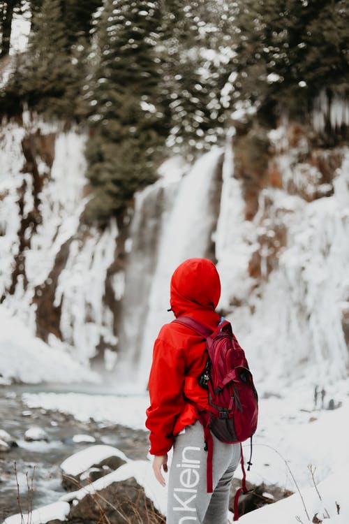 红色连帽衫站在雪地上的人 · 免费素材图片