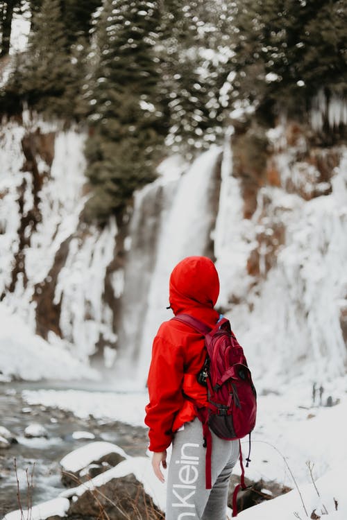 红色连帽衫站在雪地上的人 · 免费素材图片