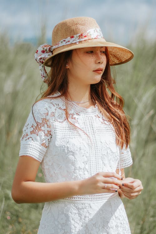 白色花衬衫戴着棕色草帽的女人 · 免费素材图片