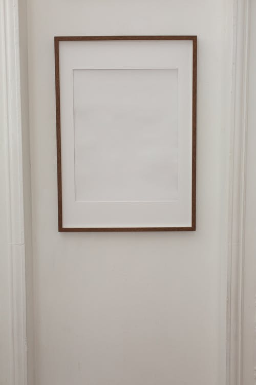 白墙上的白色木制框架 · 免费素材图片