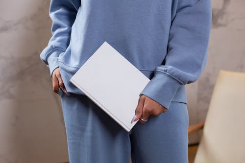 拿着白皮书的蓝色长袖衬衫的人 · 免费素材图片