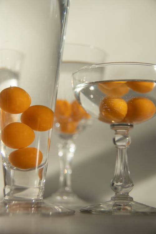 透明酒杯与橙色水果 · 免费素材图片