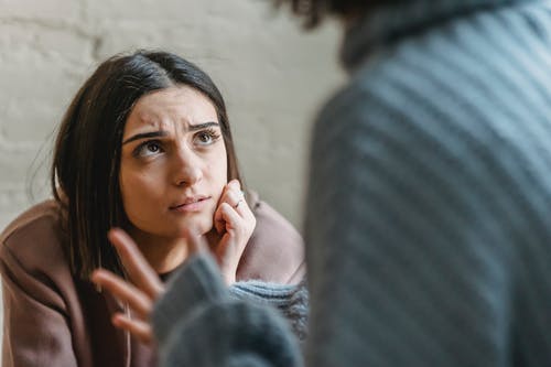 抱着她的脸的灰色毛衣的女人 · 免费素材图片