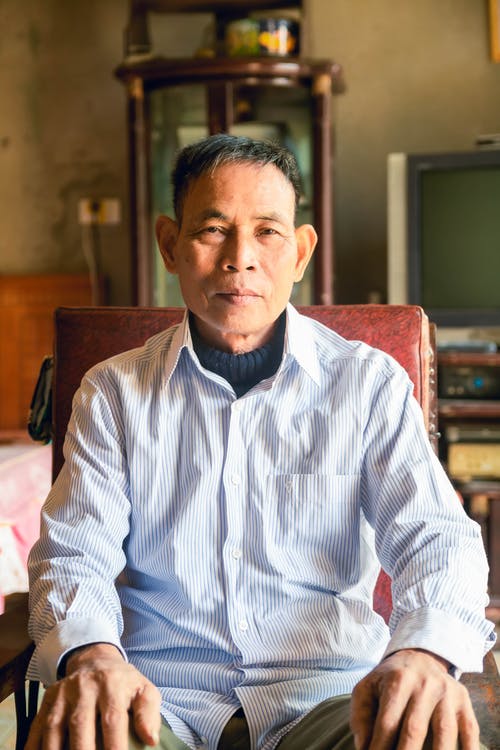 坐在椅子上的白色和蓝色细条纹礼服衬衫的男人 · 免费素材图片